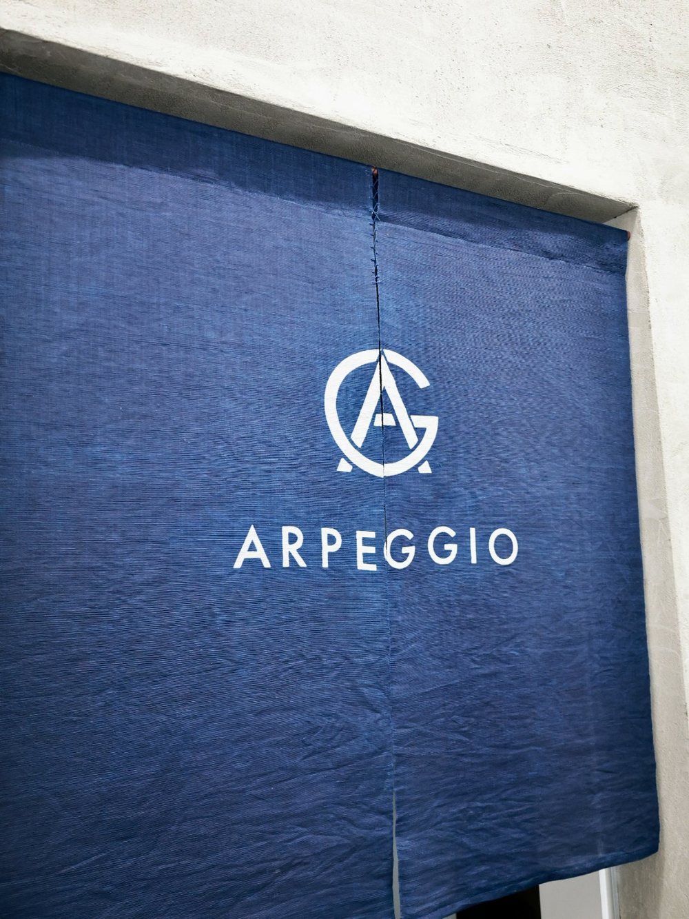 ARPEGGIOのロゴを染め抜いた藍染ののれん